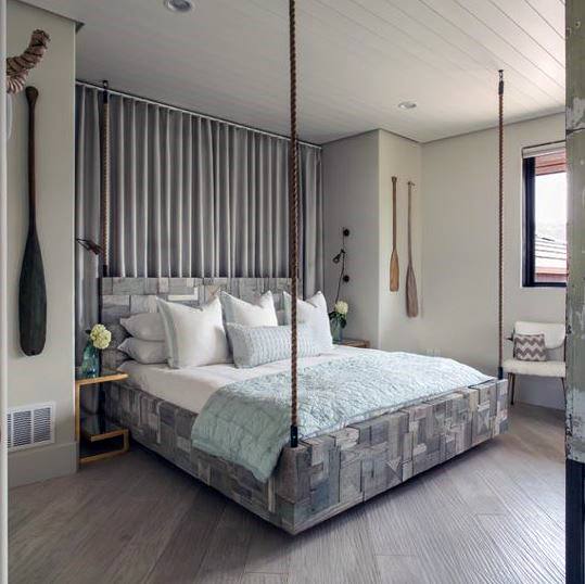 A rustic-themed bedroom featuring a hanging bed with sturdy rope supports, paired with soft neutral tones and nautical decor accents for a cozy, elegant vibe.