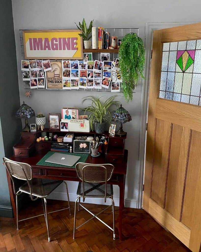 small home office space vintage wood desk photo collage hanging plants 
