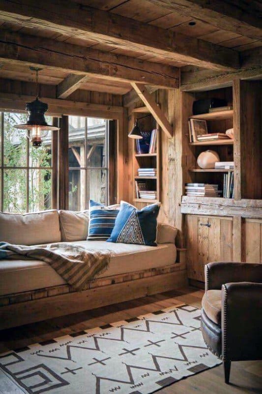 Cozy cabin nook with built-in shelves, rustic wood details, and a comfy daybed.