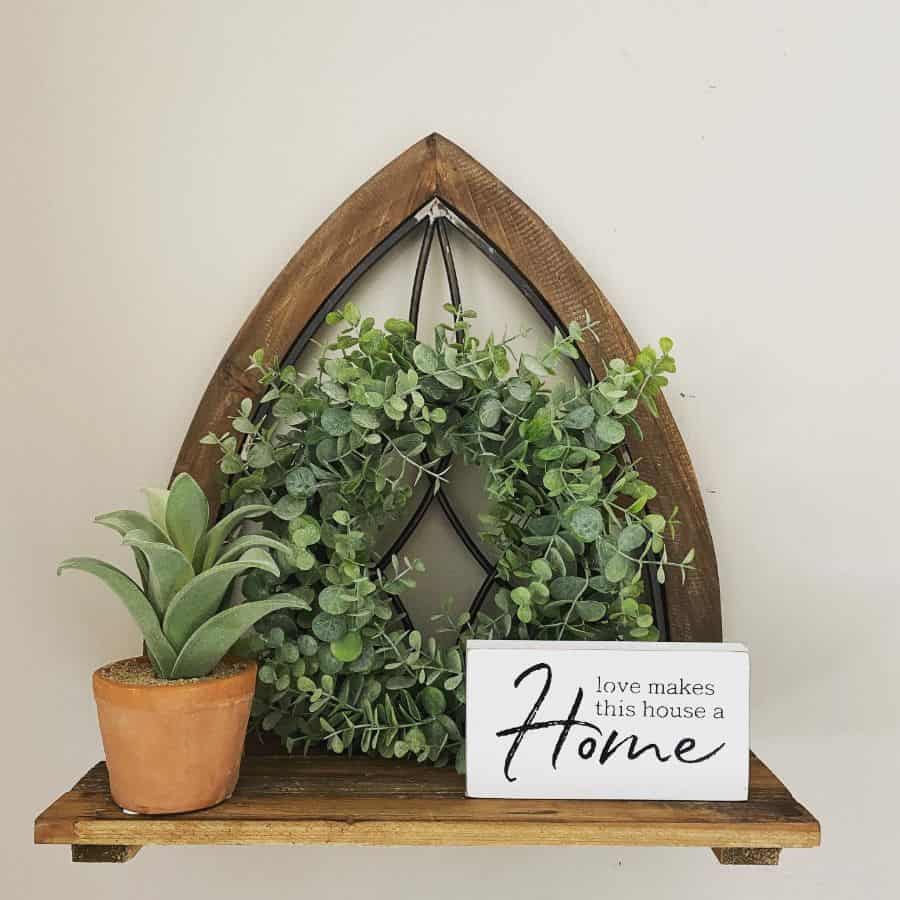wood wall shelf with plants and sign