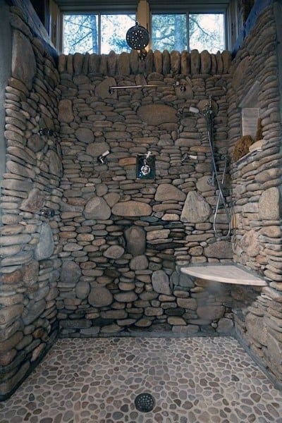 Stone-walled shower with pebble floor, creating a rustic, natural oasis