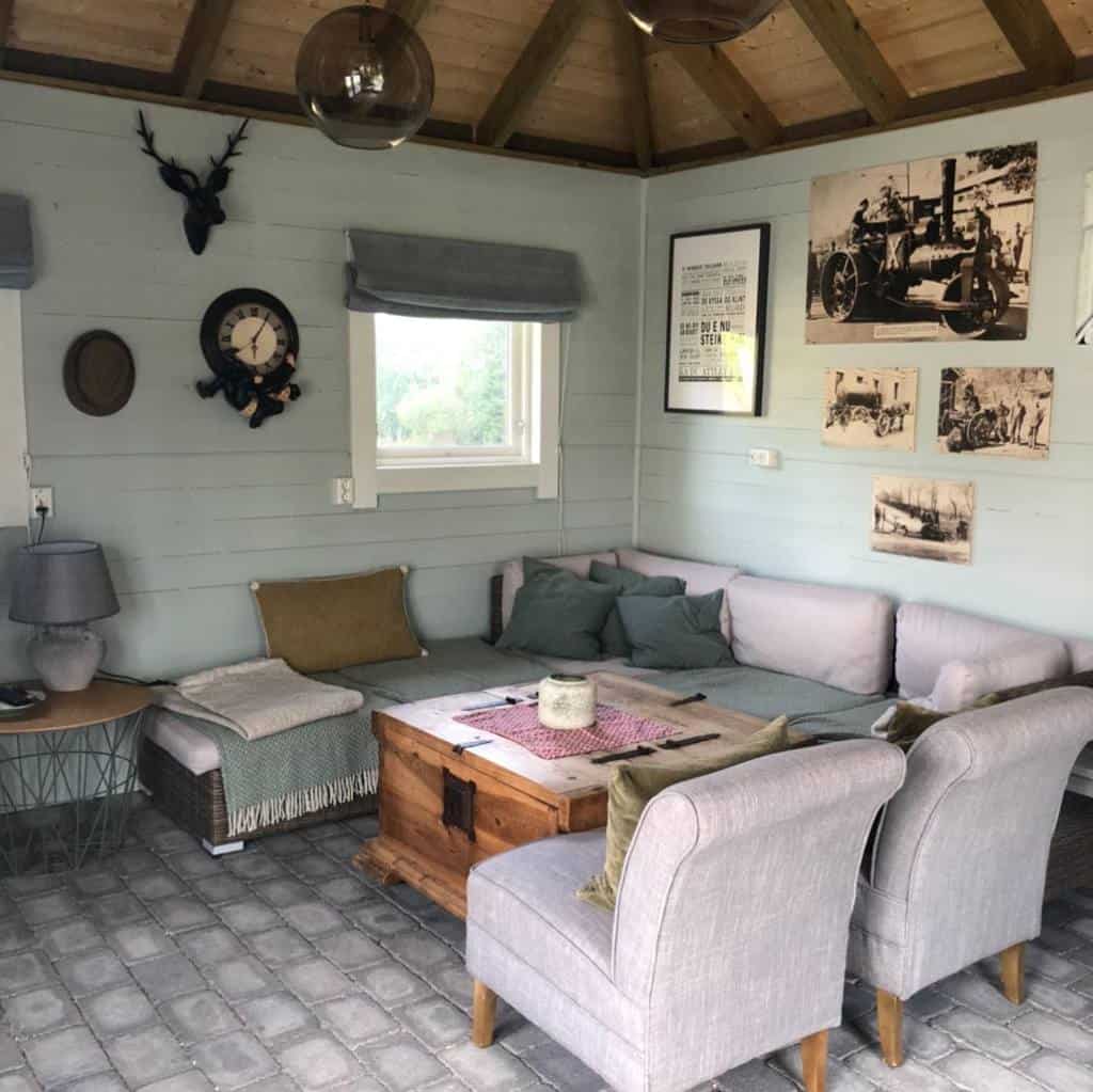 farmhouse style she shed with purple sofa and armchairs 