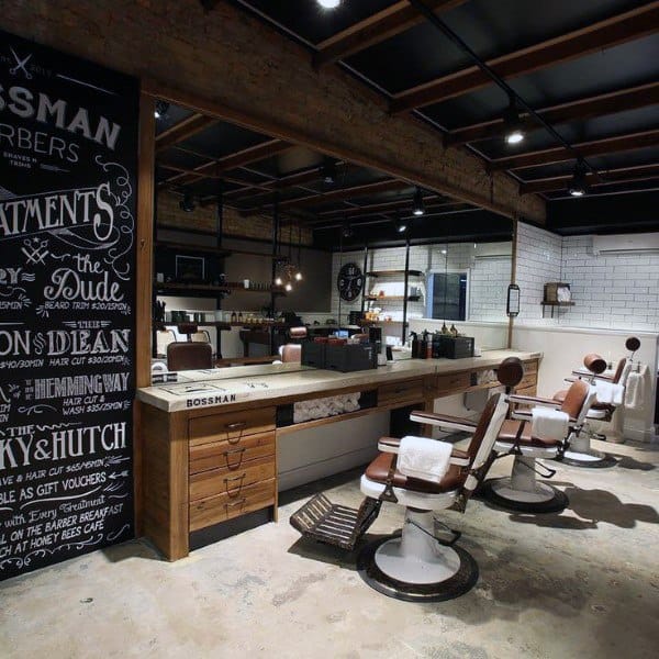 Rustic barbershop with leather chairs, wooden counters, chalkboard wall, and subway tiles.