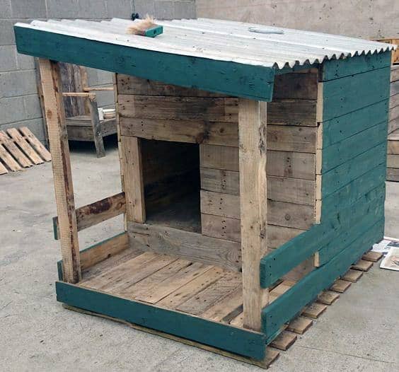 Teal-accented wooden dog house, crafted from pallets