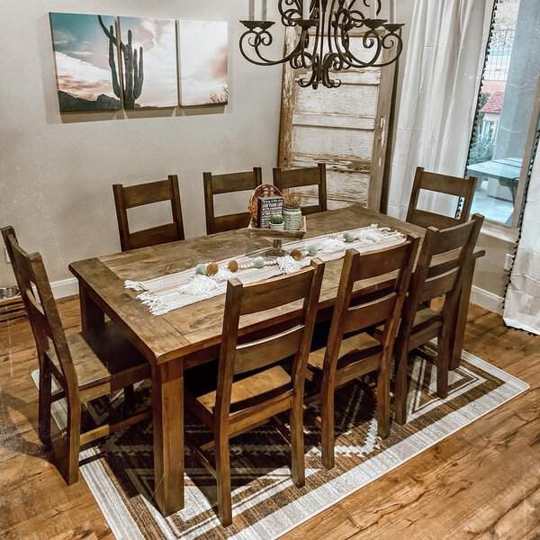 Rustic boho dining room with wooden table, chairs, and desert-inspired decor.