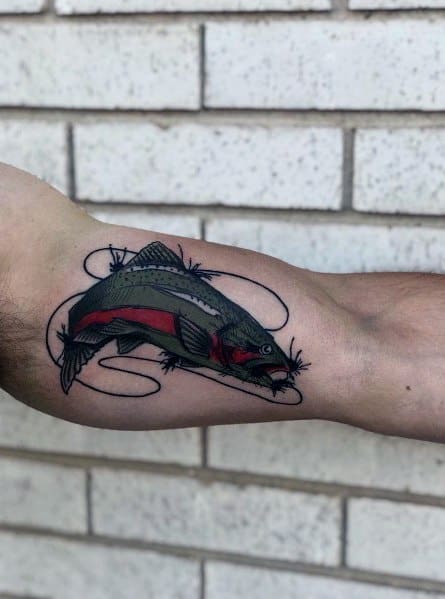 Detailed tattoo of a salmon caught on a fishing line, featuring bold black outlines and red accents, placed on the forearm for a striking design.