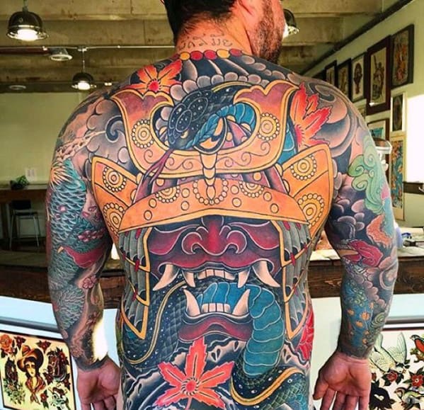 Man with intricate full-back tattoo featuring a colorful samurai helmet and serpent