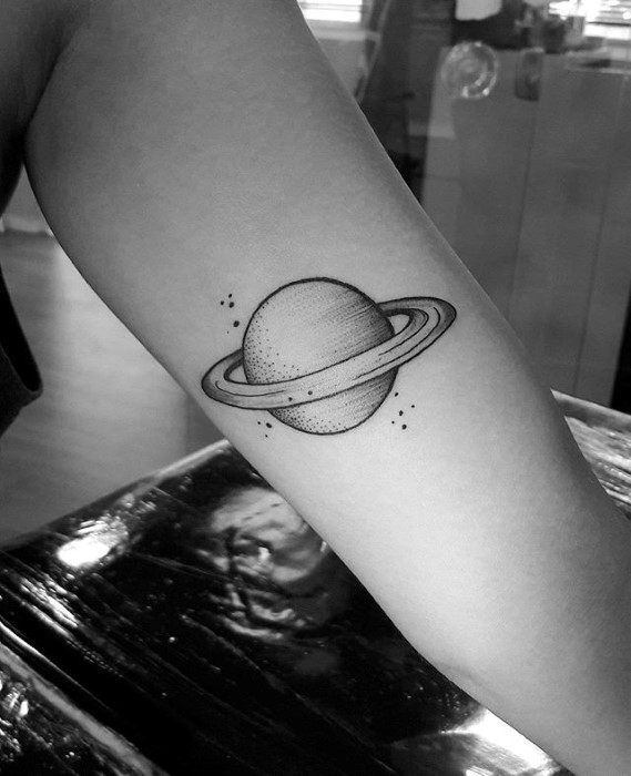 Minimalist Saturn tattoo design for men featuring clean lines, dotwork shading, and small stars surrounding the ringed planet.