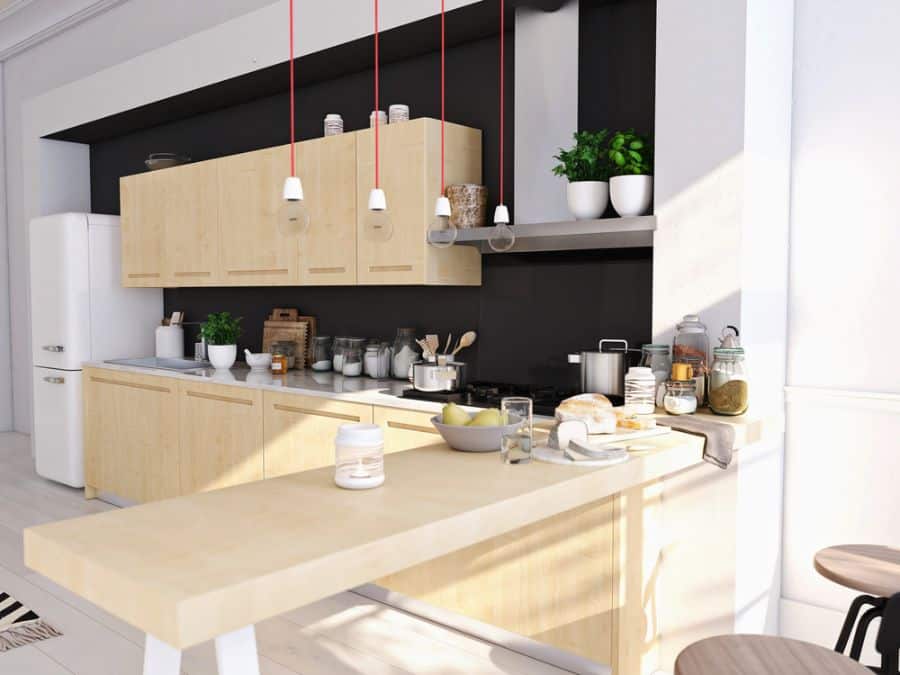 Scandinavian kitchen with light wood cabinets, black backsplash, and hanging pendant lights.