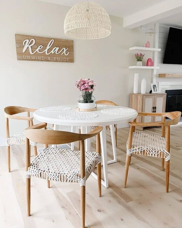Scandinavian boho dining room with light wooden chairs, white table, and relaxed decor.