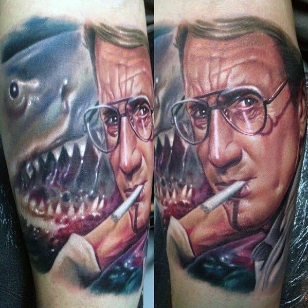 Realistic color tattoo of Chief Brody from *Jaws*, featuring his intense expression, cigarette, and the menacing shark in the background for a cinematic effect.