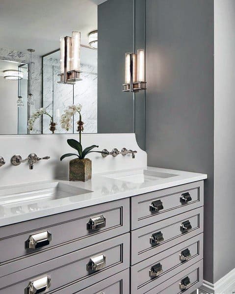 Bathroom with double vanity and modern linear wall sconces above sinks.