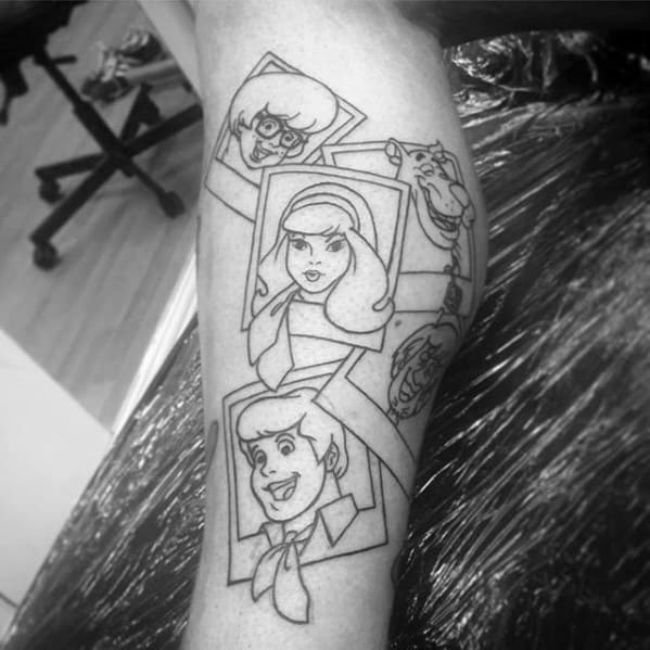 Black and white tattoo of the Scooby-Doo gang framed in photo-style boxes, featuring Velma, Daphne, Fred, Shaggy, and Scooby.