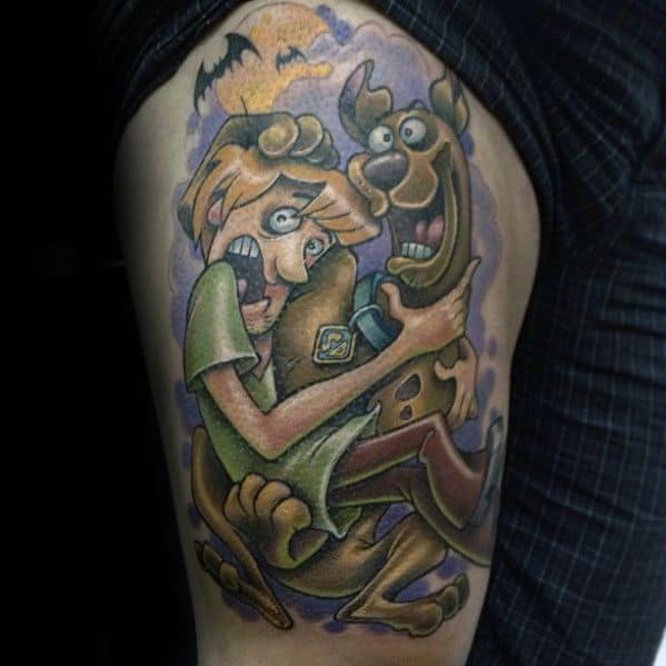 Tattoo of Shaggy and Scooby-Doo clinging to each other in fear, with bats and a spooky purple night sky in the background.