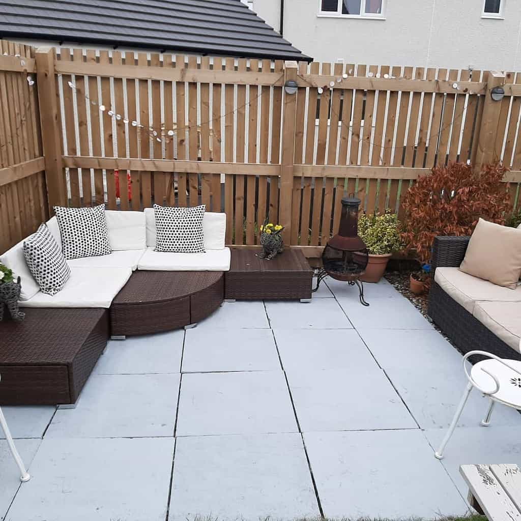 paver patio wicker sofa wood fence fireplace 