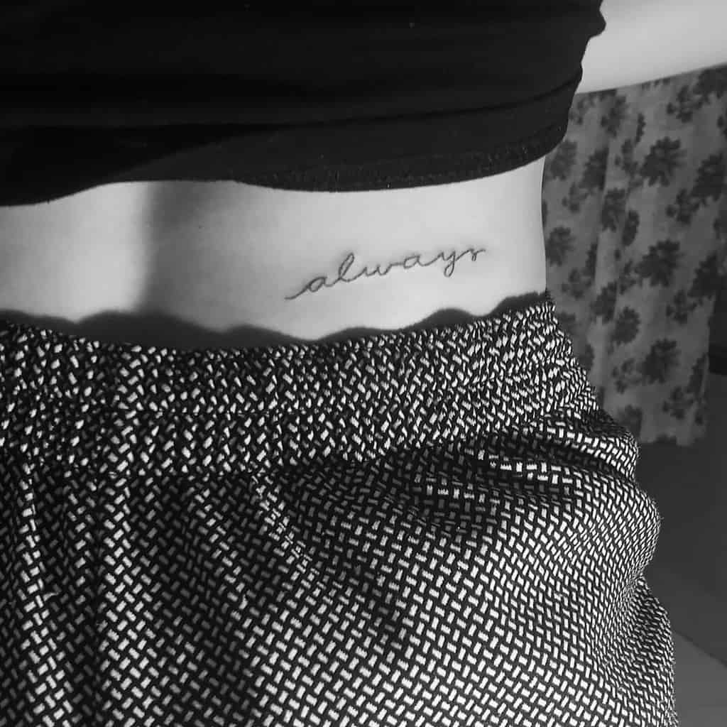 A side view of a woman's waist with the word "always" tattooed on the skin