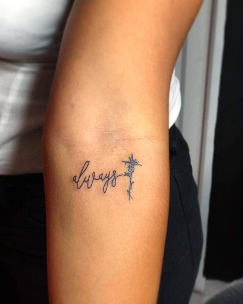 Tattoo on an arm reads "always" with a small flower design