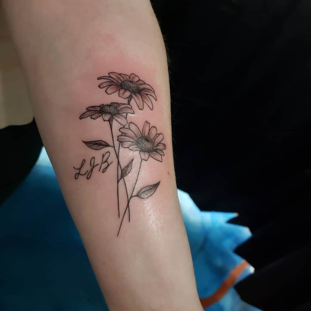 Forearm tattoo black and grey fine line script daisy bouquet