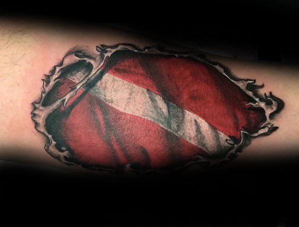 Realistic torn-skin tattoo revealing a red and white scuba diving flag beneath the surface.