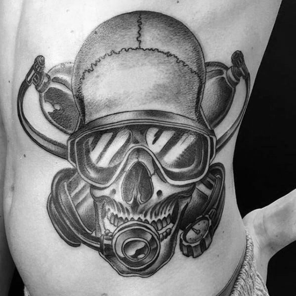 Black and grey tattoo of a skull wearing scuba diving gear, including goggles and regulator, with twin air tanks behind.