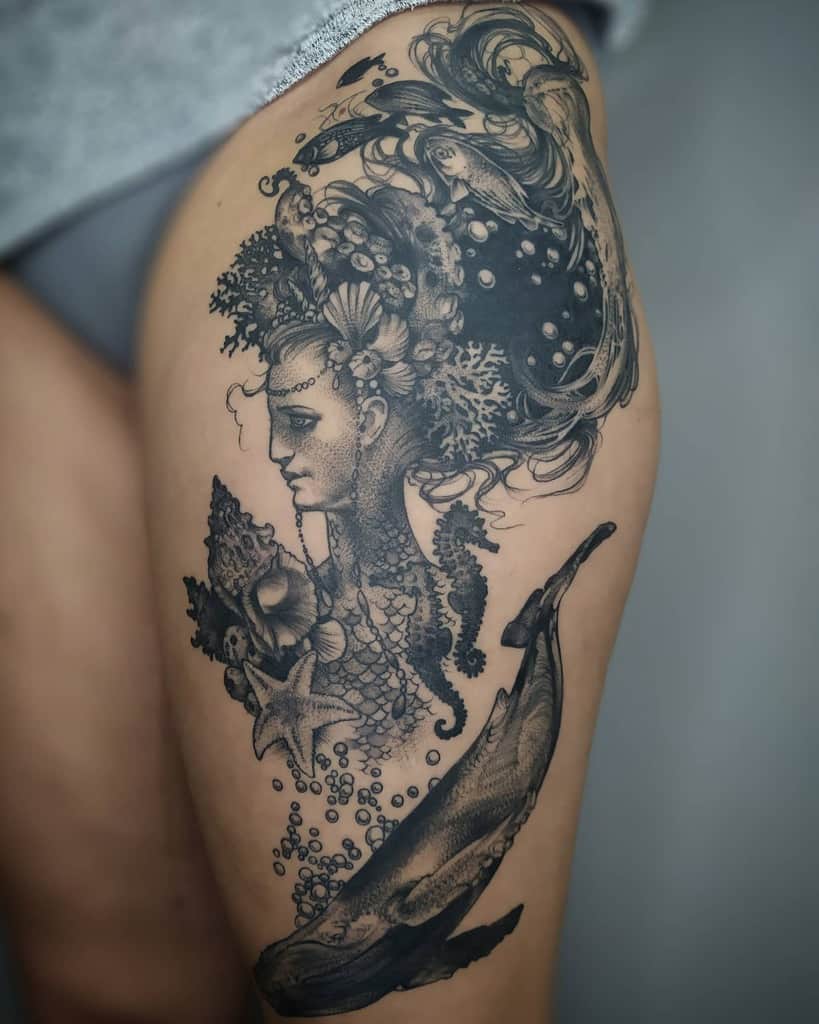 Black and grey tattoo of an ethereal mermaid with an ocean-inspired headdress, surrounded by sea creatures, coral, and a whale.