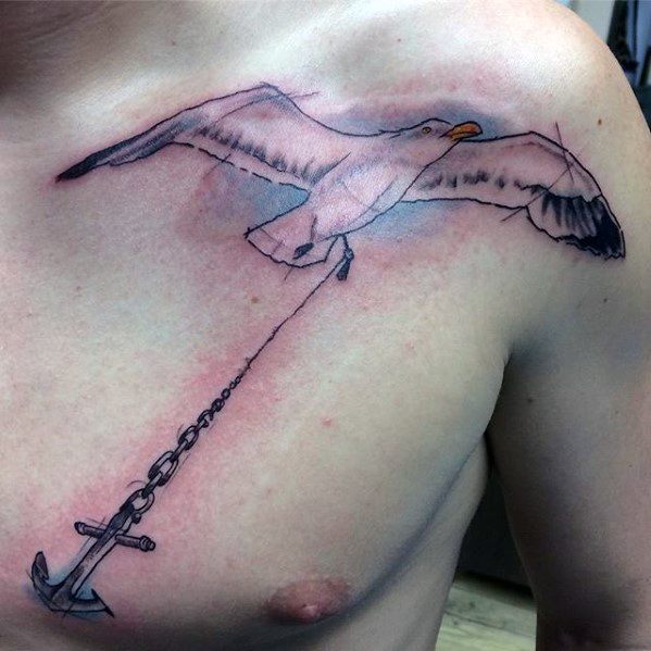 Tattoo of a seagull on a person's chest gripping an anchor by a chain in its beak