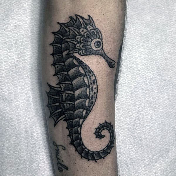 Black and grey seahorse tattoo on forearm, featuring intricate dot work shading and bold outlines for a detailed and artistic design.