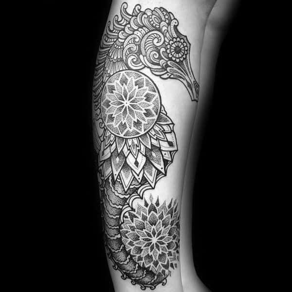Ornamental seahorse tattoo on arm, featuring intricate mandala patterns and fine dot work for a detailed and artistic black ink design.