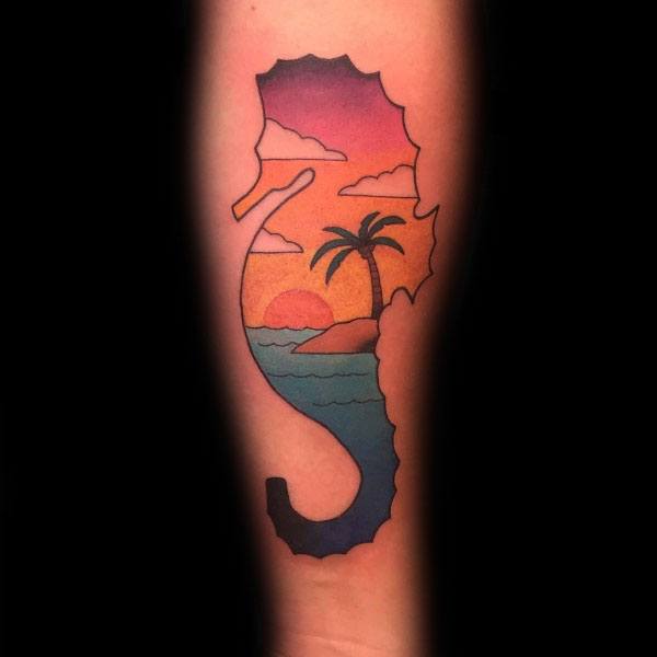 Minimalist seahorse tattoo on forearm, featuring a tropical sunset scene with palm trees and ocean waves inside its silhouette for a serene design.