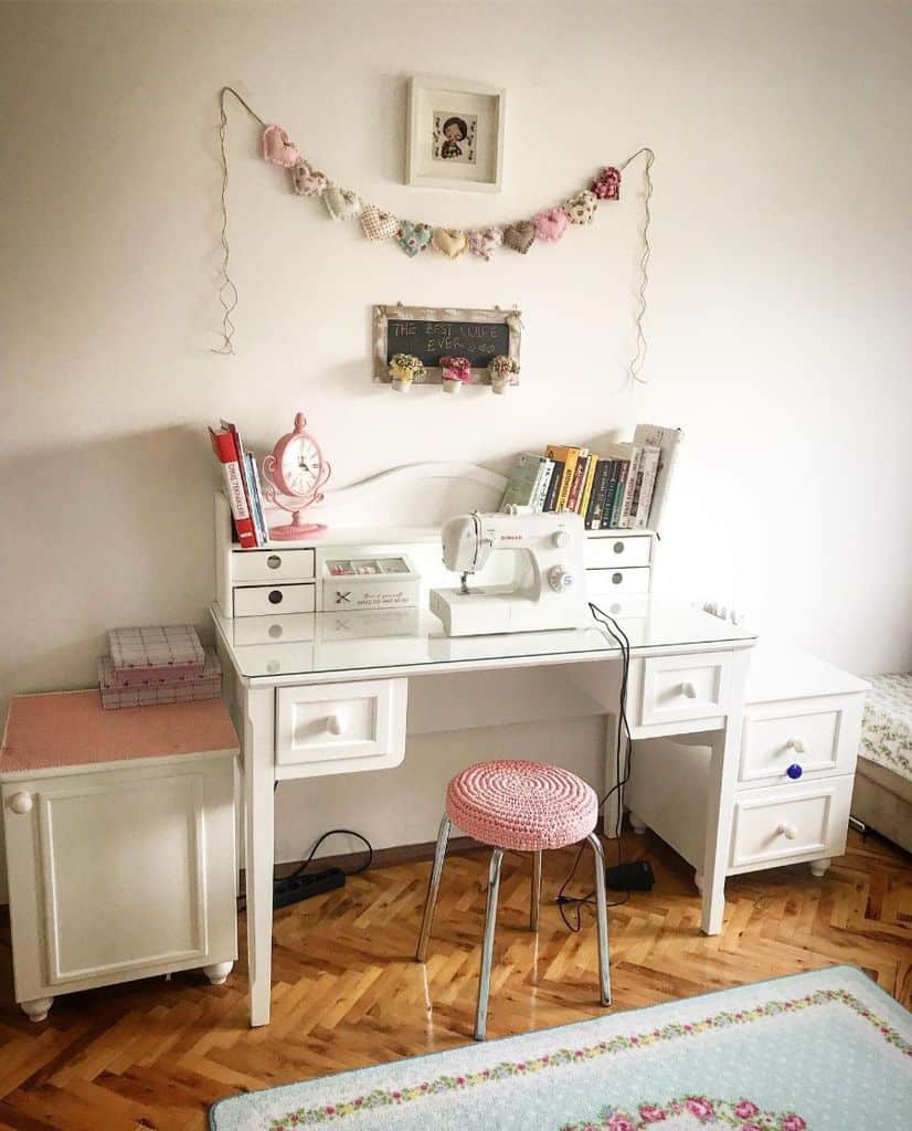 Charming sewing space with vintage decor, a white desk, pastel accents, and a cozy handmade stool
