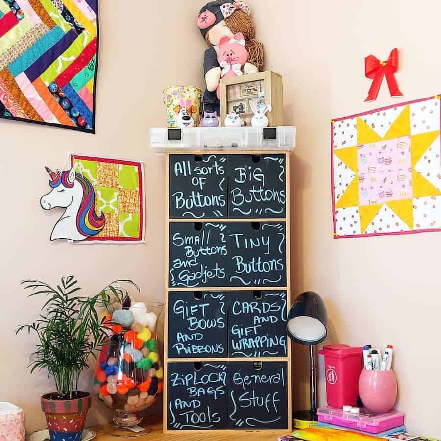 Colorful crafting corner with labeled storage, playful decor, wall quilts, and a vibrant display of sewing supplies