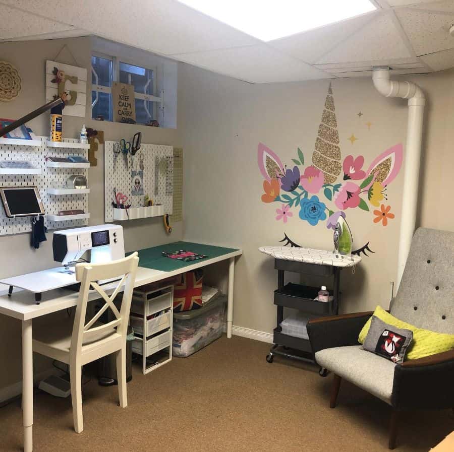 Whimsical sewing space with a unicorn wall decal, organized workstation, and a cozy chair for relaxation