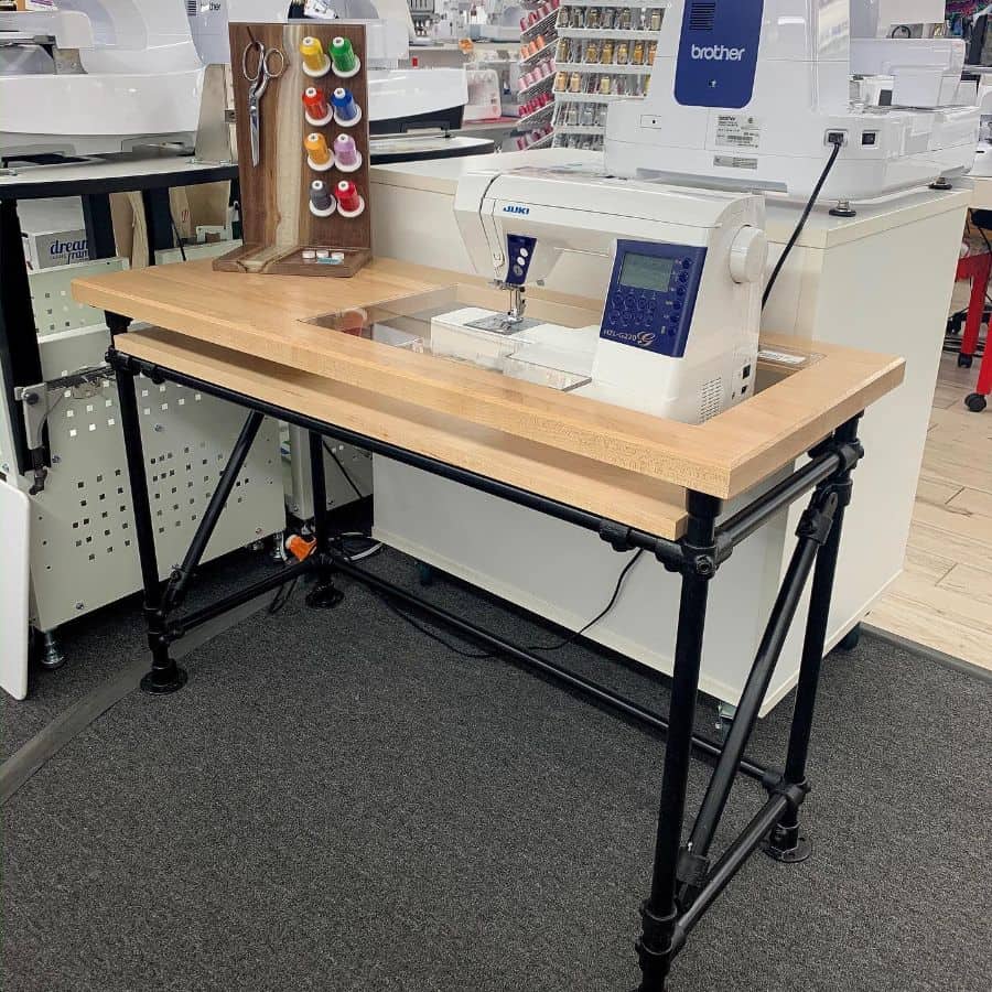 Modern sewing table with industrial-style frame, built-in machine placement, and organized thread storage