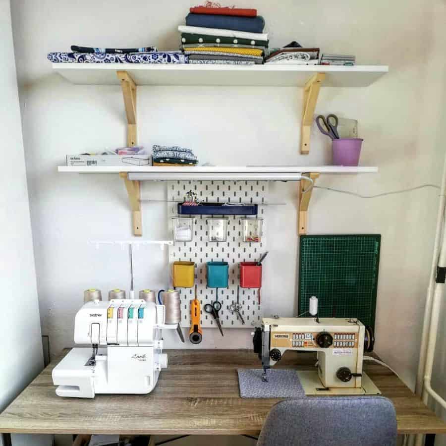 Minimalist sewing corner with wall shelves, a pegboard for tools, and dual sewing machines on a wooden desk