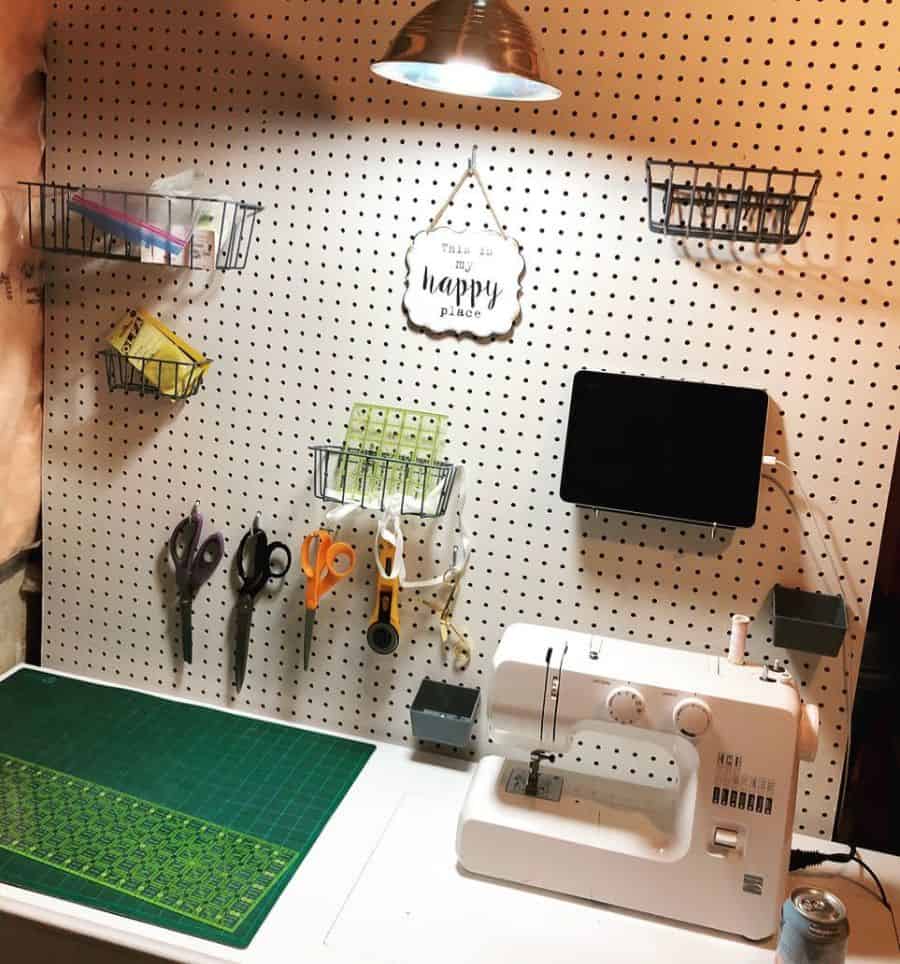 Functional sewing setup with a pegboard for tools, wire baskets for storage, a sewing machine, and task lighting