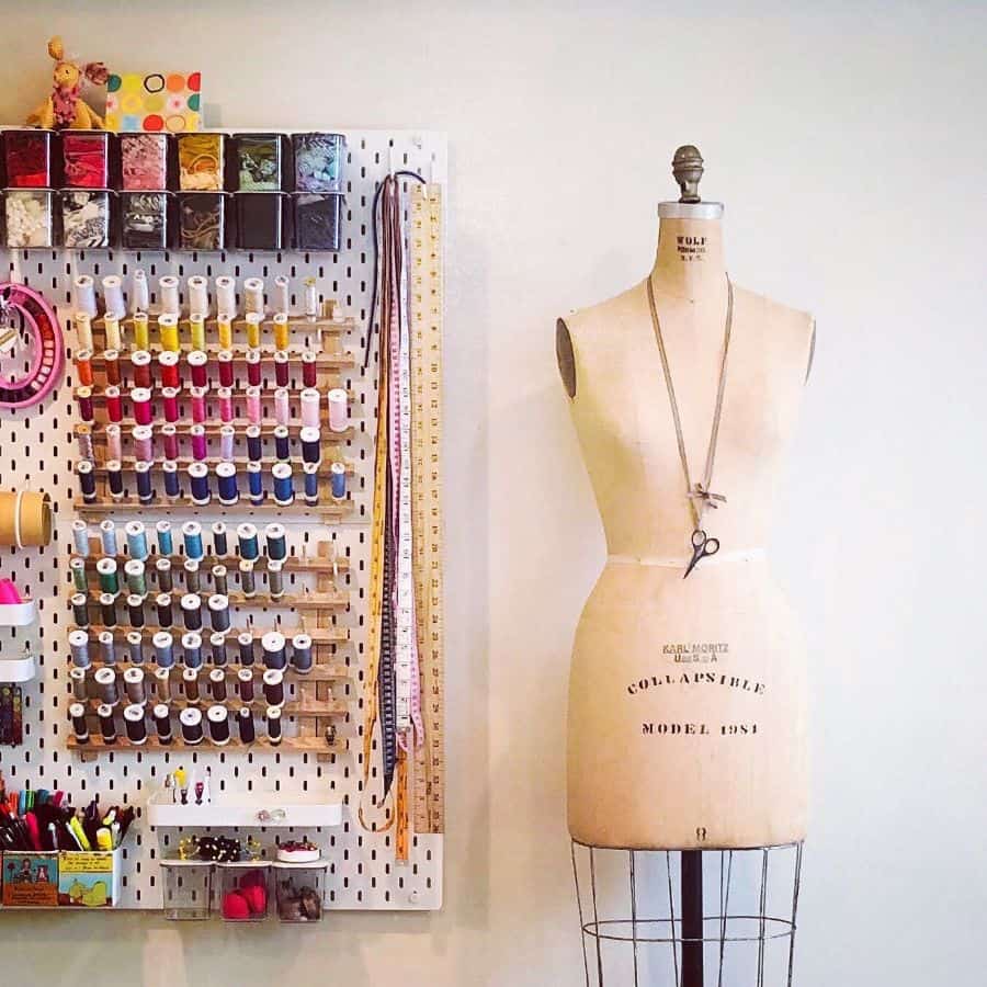 Stylish sewing station with a pegboard for thread and tools, and a vintage dress form for design projects