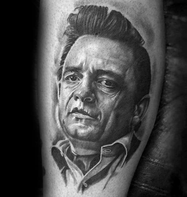 Black and gray forearm tattoo of Johnny Cash's face with a serious expression