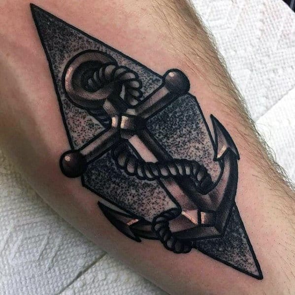 Bold black and gray anchor tattoo with geometric background, intricate shading, and a wrapped rope, symbolizing strength, stability, and resilience.