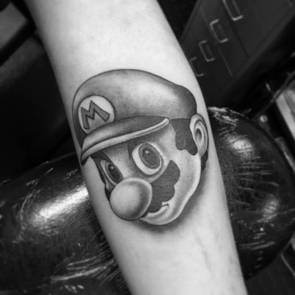 Black and gray *Super Mario* tattoo featuring realistic shading and depth, capturing Mario’s determined expression in a bold, classic design.