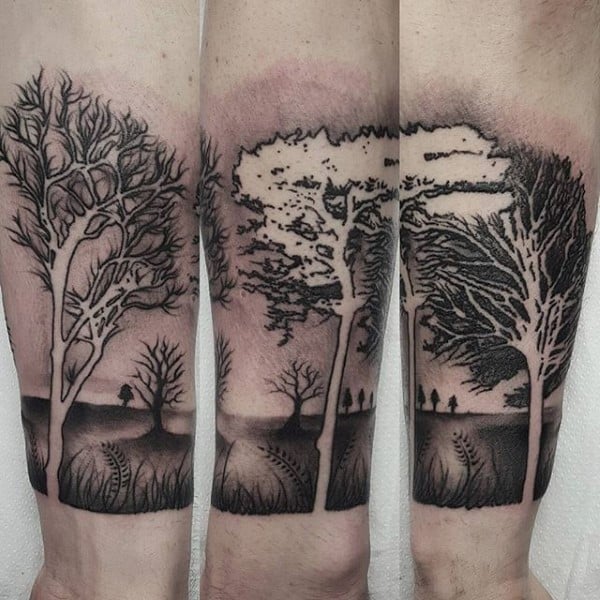 Trees with bare branches and silhouettes on tattooed forearms in black ink