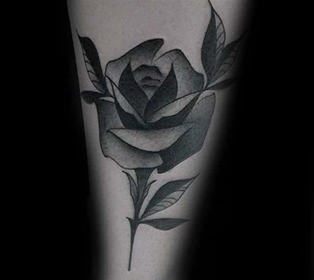 Tattoo of a black and gray rose with leaves
