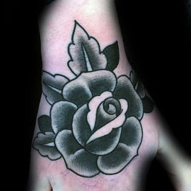 Black and white rose tattoo on a hand