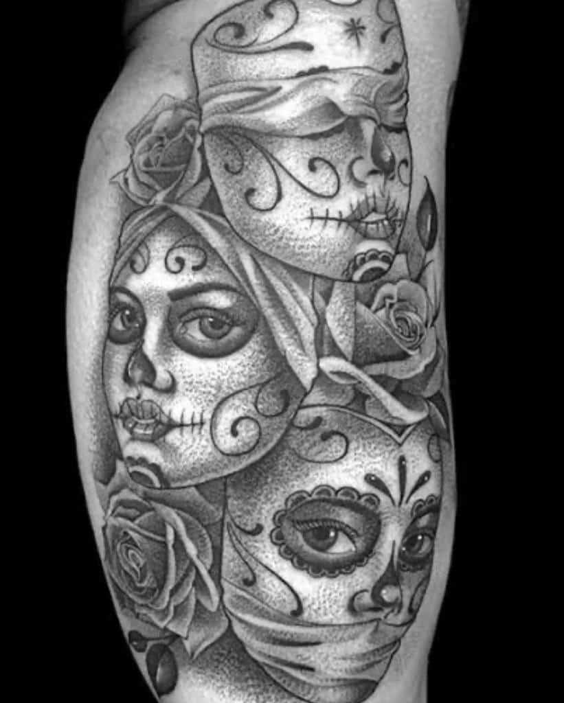 Black and gray tattoo of three decorative faces stacked vertically, representing 'Hear No Evil, See No Evil, Speak No Evil,' with intricate patterns and roses
