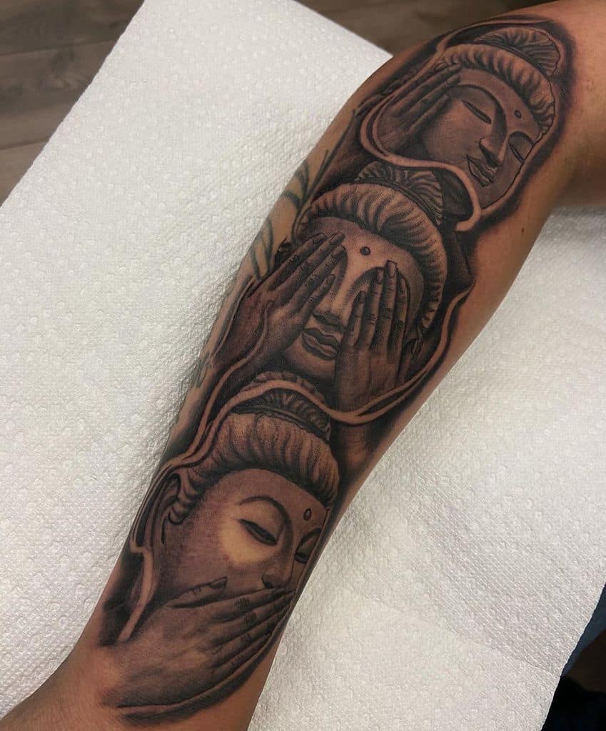 Tattoo of three Buddha faces on an arm, depicting "see no evil, hear no evil, speak no evil"