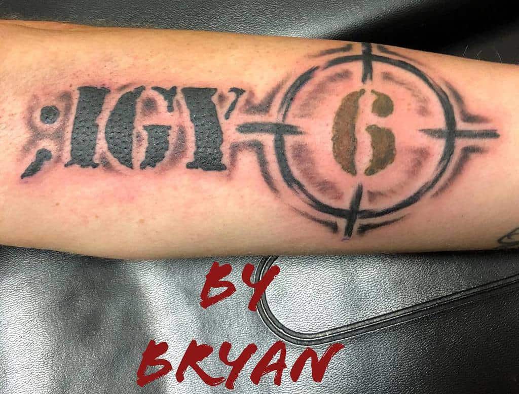 Tattoo of "; IGY 6" with a crosshair around the "6" on an arm