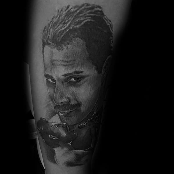 Black and grey tattoo of Freddie Mercury smiling gently while holding a cat, capturing his softer and more personal side.