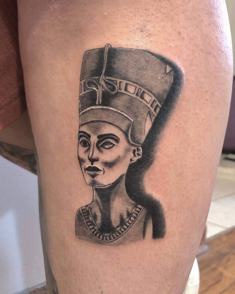 Tattoo of Queen Nefertiti with a tall headdress on a thigh