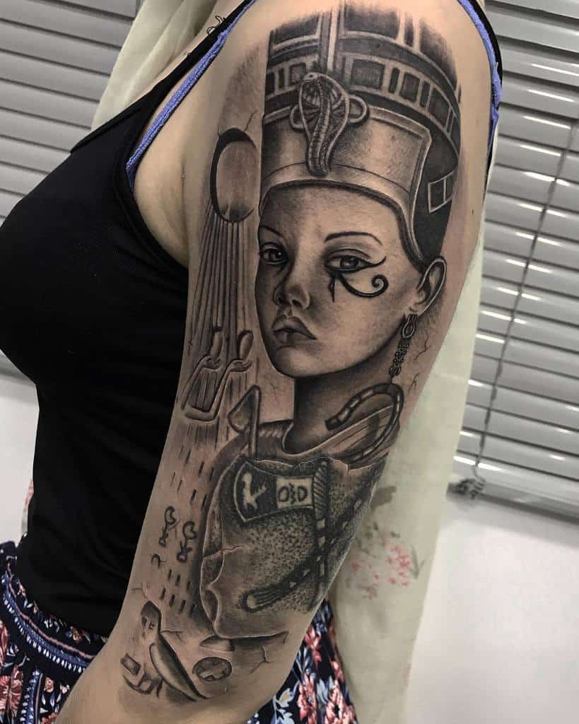 Tattoo of Nefertiti, the ancient Egyptian queen, and symbols on an upper arm