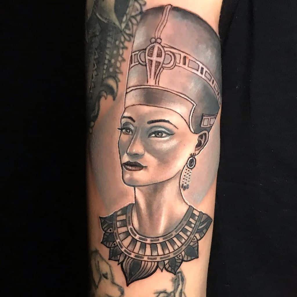 Tattoo of an Egyptian queen with a headdress and necklace on a person's arm