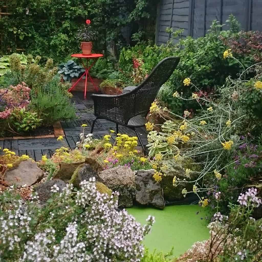 wood patio in lush garden with pond